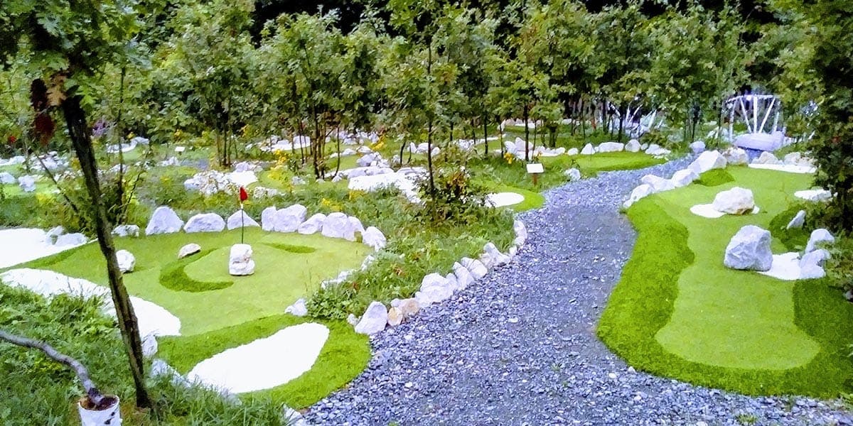 Staze avanturističkog mini golfa u Eko Golf Parku na Breškama, s bijelim kamenjem i šumom u pozadini